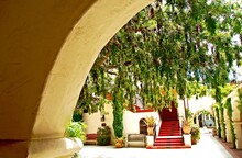 Spanish Mission Style Architecture In Laguna Beach, California With Hanging Trees In The Courtyard
