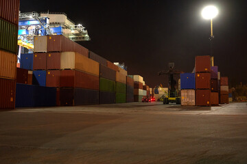 Wall Mural - operation of container terminal at night. Unloading container ship at night. Mooring cranes unload container ship at night