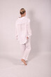 © Шамиль Алиев - A young girl in white house clothes on a white background in the studio is standing with her back