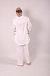 © Шамиль Алиев - A young girl in white house clothes on a white background in the studio is standing with her back