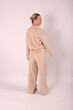© Шамиль Алиев - A young girl in beige home clothes on a white background in the studio