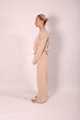 © Шамиль Алиев - A young girl in beige home clothes on a white background in the studio