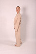© Шамиль Алиев - A young girl in beige home clothes on a white background in the studio