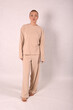 © Шамиль Алиев - A young girl in beige home clothes on a white background in the studio