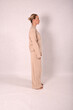 © Шамиль Алиев - A young girl in beige home clothes on a white background in the studio