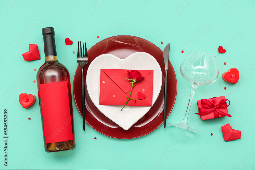 Table setting for Valentine's Day with envelope and rose on green background