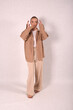 © Шамиль Алиев - A young girl in beige home clothes on a white background in the studio