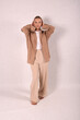 © Шамиль Алиев - A young girl in beige home clothes on a white background in the studio