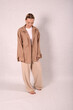 © Шамиль Алиев - A young girl in beige home clothes on a white background in the studio