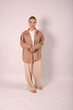 © Шамиль Алиев - A young girl in beige home clothes on a white background in the studio