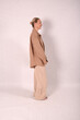 © Шамиль Алиев - A young girl in beige home clothes on a white background in the studio