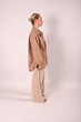 © Шамиль Алиев - A young girl in beige home clothes on a white background in the studio