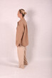 © Шамиль Алиев - A young girl in beige home clothes on a white background in the studio