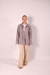 © Шамиль Алиев - A young girl in beige home clothes on a white background in the studio