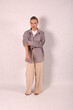 © Шамиль Алиев - A young girl in beige home clothes on a white background in the studio