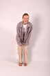 © Шамиль Алиев - A young girl in beige home clothes on a white background in the studio