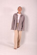 © Шамиль Алиев - A young girl in beige home clothes on a white background in the studio
