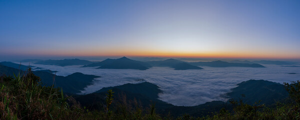 Wall Mural - Beautiful landscape on the mountains at sunrise. Spectacular view in foggy valley covered forest under morning sky. Panorama Picture