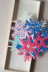 Sticker - paper snowflakes pile atop a wooden box