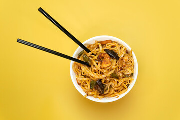 Wall Mural - Noodles with chicken meat beans mushrooms carrots and vegetables on bright yellow background color. top view