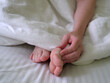female legs on a white bed. The problem with women's feet. Hallus valgus