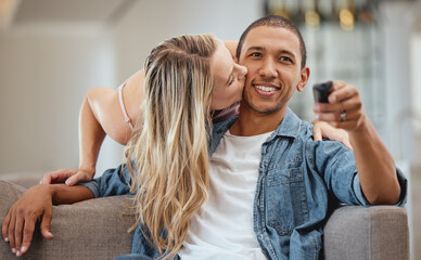 Poster - Couple, sofa and woman with cheek kiss for man, partner or husband with love, romance and care in home. Girl, surprise and kissing face of black man for bonding, happiness and relationship on couch