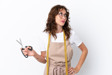 Wall Mural - Young caucasian seamstress woman isolated on white background and looking up