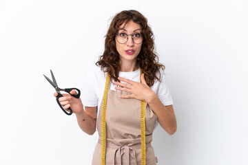 Wall Mural - Young caucasian seamstress woman isolated on white background surprised and shocked while looking right