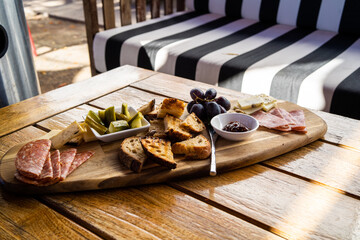 charcuterie board on wooden table at restaurant with black and white couch