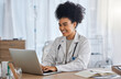 © K Davis/peopleimages.com - Black woman, doctor and laptop with smile for healthcare, email or telemedicine by work desk at the hospital. African American female medical expert smiling on computer in medicare research at clinic