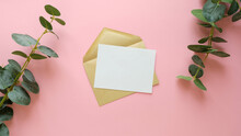 Postal Envelope And A Blank Sheet On A Pink Background. Green Plant Branches And A Letter With Space For Text