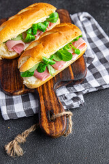 sandwich french milk buns ham, cheese, lettuce green leaves bio product fresh healthy meal food snack on the table copy space food background rustic top view