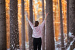 Kobieta medytująca o zachodzie słońca w zimowym lesie