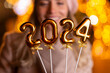 © Dexon Dee - Young woman holding 2024 number for new year eve