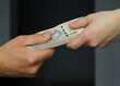 male and female hands holding a bundle of 200 zloty banknotes. selective focus