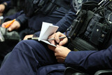 Fototapeta  - Policjant z notatnikiem służbowym na odprawie do służby. 