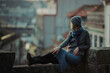 © De Visu - A woman sits on an ancient stone wall in downtown of Porto, Portugal.