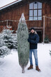 © Aleksandr - Young man stand by Christmas tree. Big tree for big family. Happy winter holidays