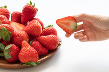 Strawberries And A Hand Holding Cut Strawberries
