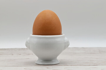 Fresh egg in an eggcup isolated on white background. Traditional food for healthy breakfast.