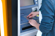 © Tatonka - Woman uses the ATM and enters the password on the keyboard