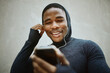© S Fanti/peopleimages.com - Music, phone and man against a wall in city for fitness, running and training with podcast, audio and wellness track. Radio, black man and smartphone for for listening to playlist before a workout