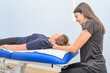 A physical therapist treats a patient's neck and cervical