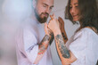 © Westend61 - Happy hipster couple with tattoo on hands dancing together
