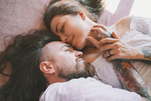 Romantic Hipster Couple Lying On Bed At Home
