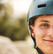 © Clement C/peopleimages.com - Closeup portrait, cycling helmet and smile for man at mountain bike park, competition or contest. Happy cyclist, face zoom and safety for bicycle race, extreme sports and focus on vision for winning