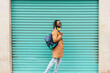 © Renata Hamuda - african american man in dreadlocks with stylish sunglasses and backpack walking on blue background