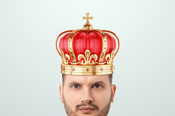 Wall Mural - A bearded man, a successful and rich businessman with a golden crown on his head on a white background in the studio. The concept of alpha male, well-deserved respect and good luck.