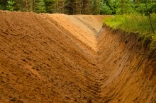 A Deep Ravine Dug By Machinery For The Construction Of A Road In The Forest.