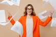 © ViDi Studio - Young happy successful employee business woman corporate lawyer 30s wear classic formal orange suit glasses work in office throw up paper account documents isolated on plain beige background studio.
